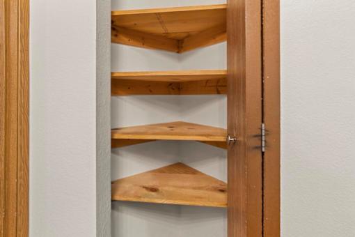 A wooden shelving unit with four shelves is open.