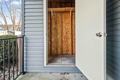 A doorway with a white door and a wooden wall in the background.