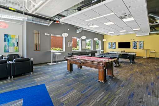 A room with a pool table and a couch.