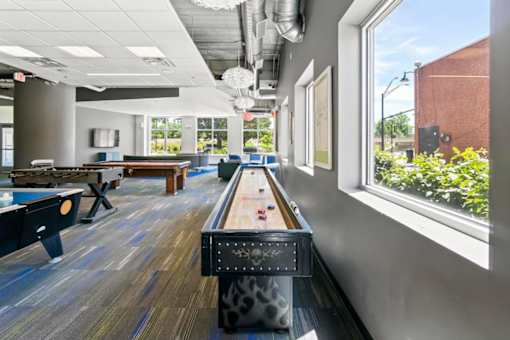 A room with a pool table and a foosball table.