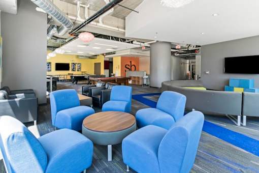 A conference room with blue chairs and a wooden table.