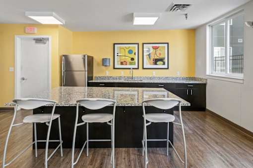 A kitchen with a yellow wall and a black counter.