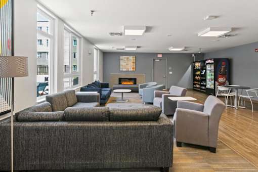 A grey couch in a room with a fireplace.