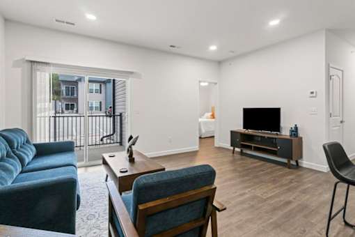 A living room with a blue couch, a wooden table, and a television.