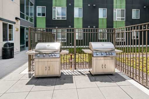 Two small outdoor grills are on a patio.