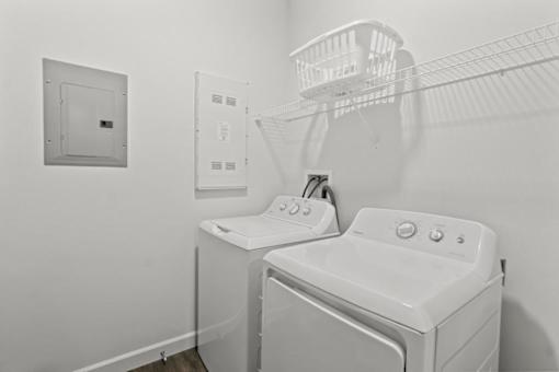 A white washing machine and dryer in a laundry room.