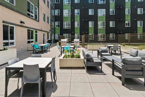 A patio with a table and chairs is surrounded by a fence.