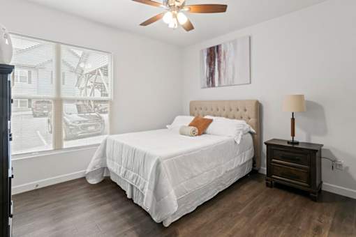A bedroom with a large bed and a ceiling fan.