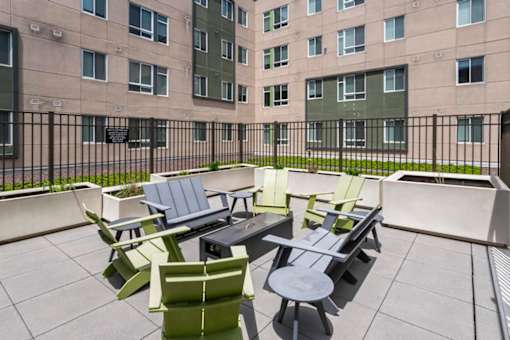 A patio with a table and chairs is in front of a building.