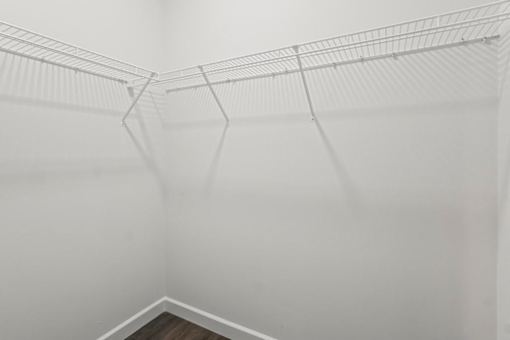 A white wire shelf in a white room.