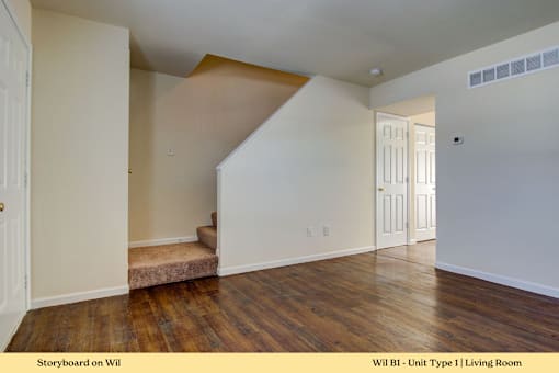 A living room with wooden floors and white walls.