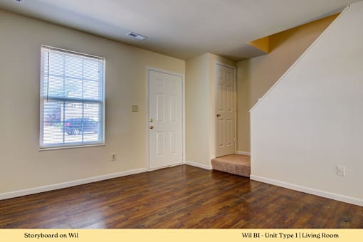 A living room with a wooden floor and white walls.
