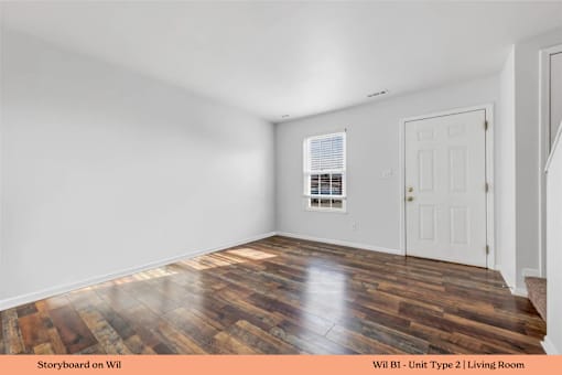 A living room with wooden floors and white walls.