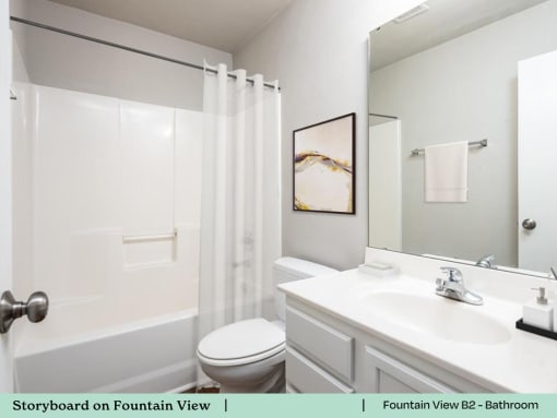 a white bathroom with a sink toilet and shower