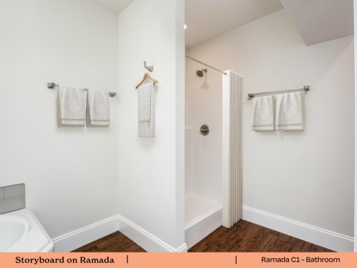 a bathroom with white towels and a shower and a toilet