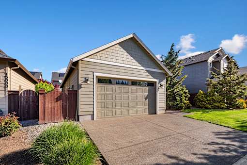 A house with a garage door and a driveway.