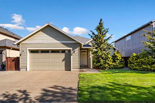 A house with a garage door and a driveway.