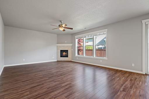 A room with a fireplace and a ceiling fan.