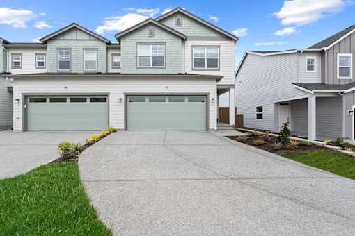 A row of houses with garages and driveways.