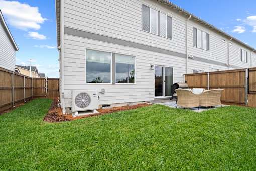 A house with a white siding and a brown fence.