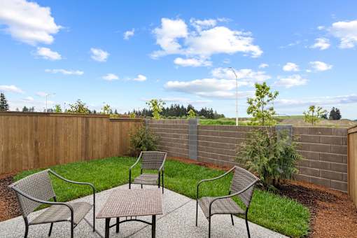 A backyard with a table and chairs.