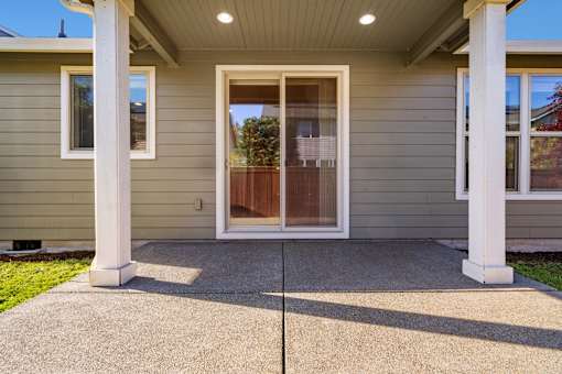 A house with a grey siding and a brown door.