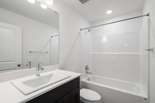 A white sink is on a countertop in a bathroom.