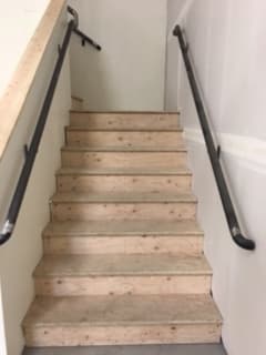 a wooden wall with metal railings on a staircase