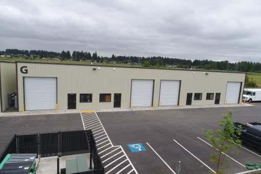 a large building with three garage doors and a parking lot