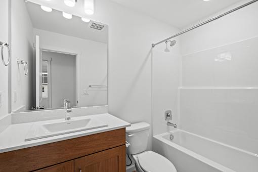 A white bathroom with a sink, toilet, and bathtub.