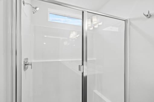 A glass door with a handle and a window in the background.