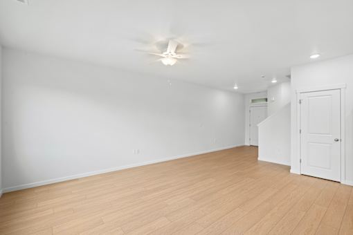 A room with a ceiling fan and wooden flooring.