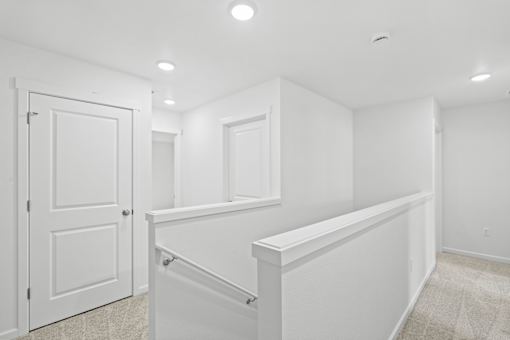 A white interior room with a door and a window.