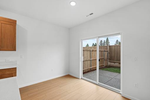 A room with a sliding glass door leading to a backyard.