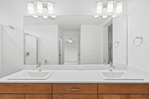 A bathroom with two sinks and a large mirror.