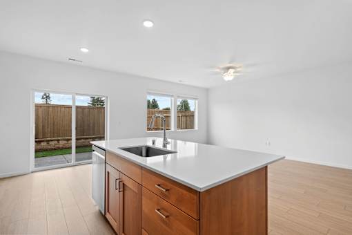 A kitchen with a white countertop and wooden cabinets.