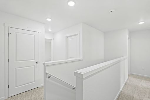 A white interior room with a door and a window.