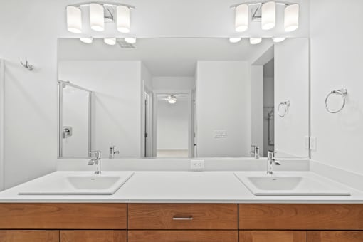 A bathroom with two sinks and a large mirror.