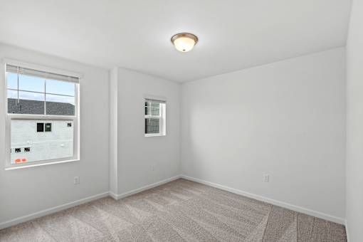 A room with a window and a poster on the wall.