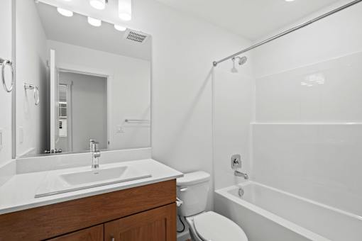 A white bathroom with a sink, toilet, and bathtub.