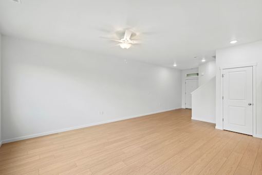 A room with a ceiling fan and wooden flooring.