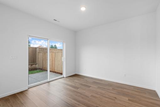 A room with a sliding glass door leading to a backyard.