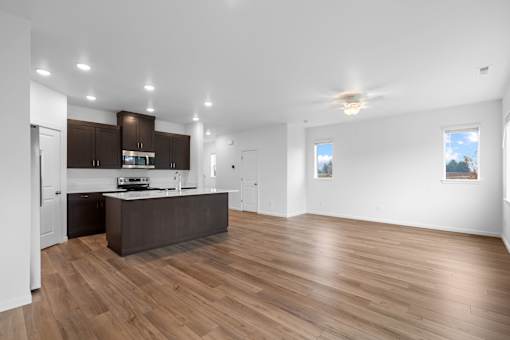 A spacious kitchen with wooden floors and a modern design.
