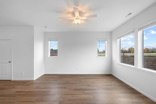 A room with wooden floors and a ceiling fan.