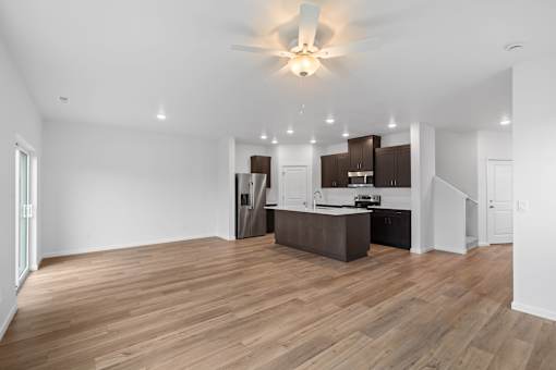 A spacious kitchen with wooden floors and modern appliances.