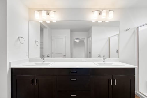 A bathroom with a white sink and a large mirror.