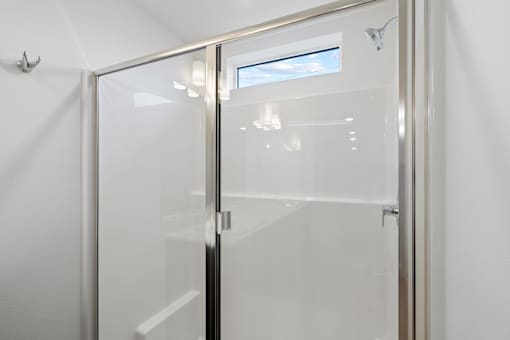 A glass door with a handle and a window in the background.