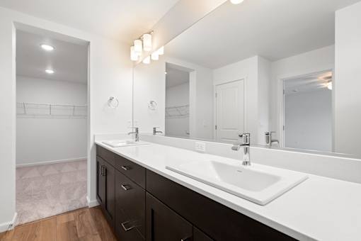 A bathroom with a white sink and a large mirror.