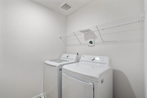 A white laundry room with a washer and dryer.