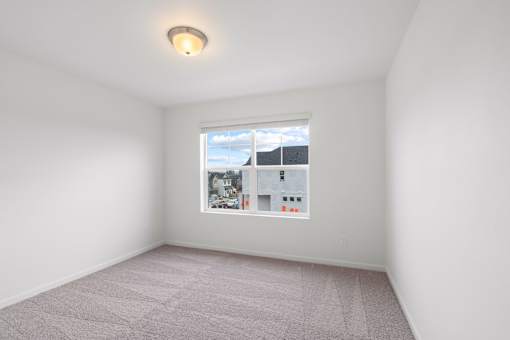 A room with a window and a picture on the wall.